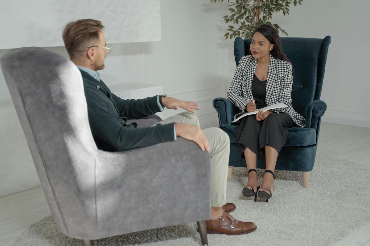 A Man and a Woman Sitting for a One on One Interview