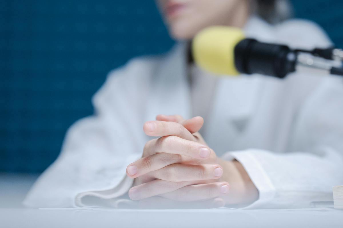 Relaxed hands resting while recording with a microphone