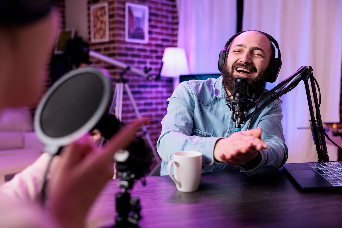 Two people recording podcast content in a studio