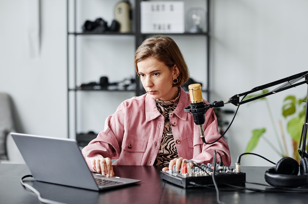 Woman setting up mixer - record a podcast remotely