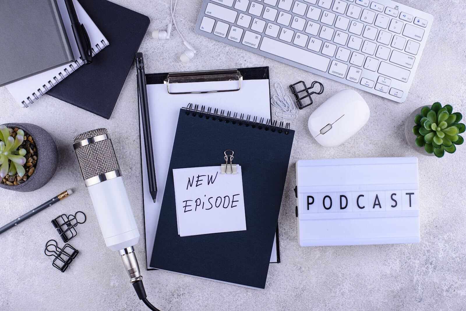 Image of podcast equipment and a notebook on a marble table 