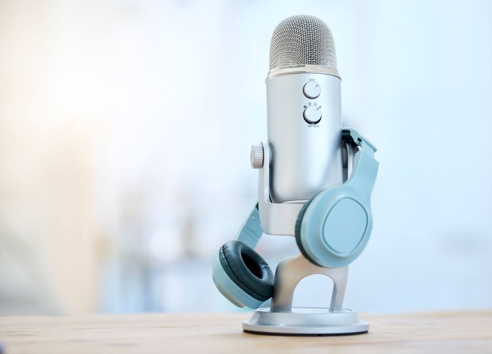 Blue Yeti USB microphone on a table with a pair of blue headphones