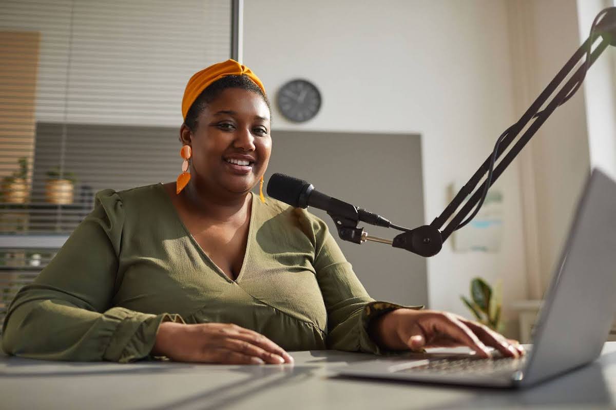 Image of a podcaster recording an episode in an office
