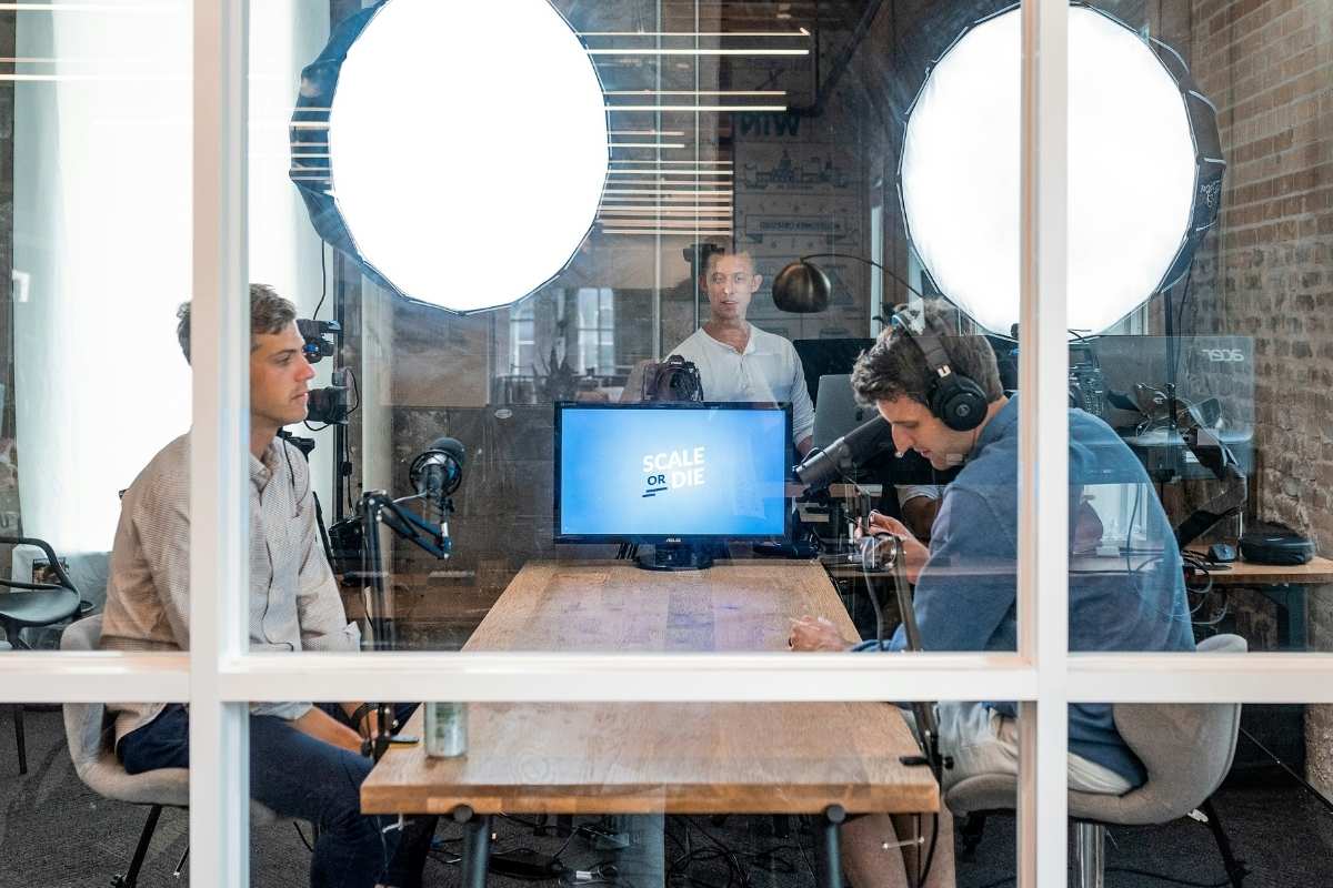 Two men in a meeting room with podcast recording equipment